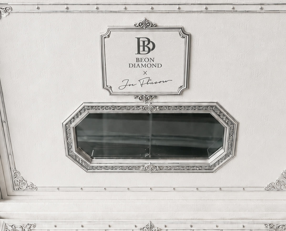 Tag B — scrolled cartouche plate with crest finials above and below